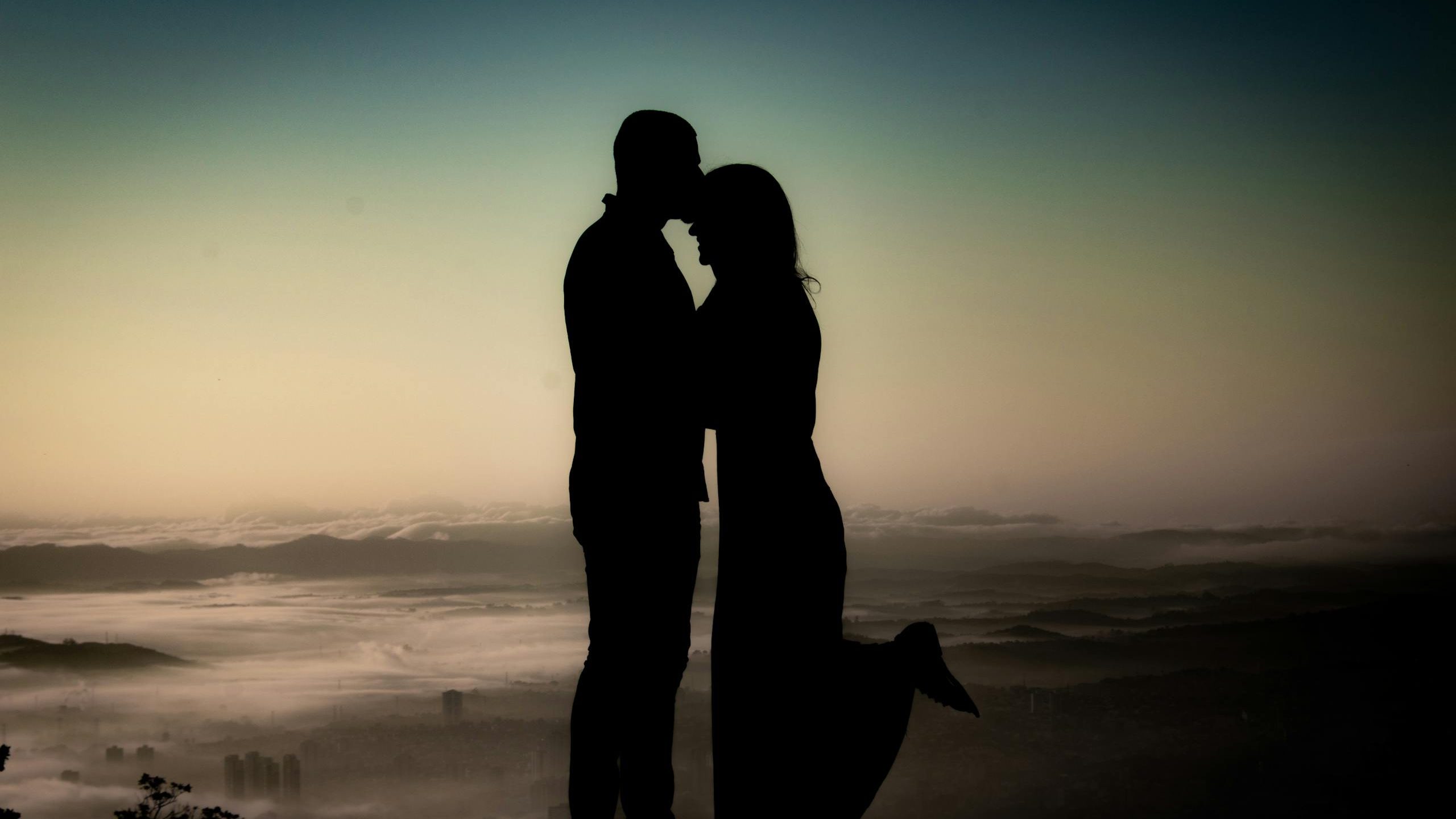 Silhouette of a couple sharing a tender moment at sunset in Mogi das Cruzes, Brazil.