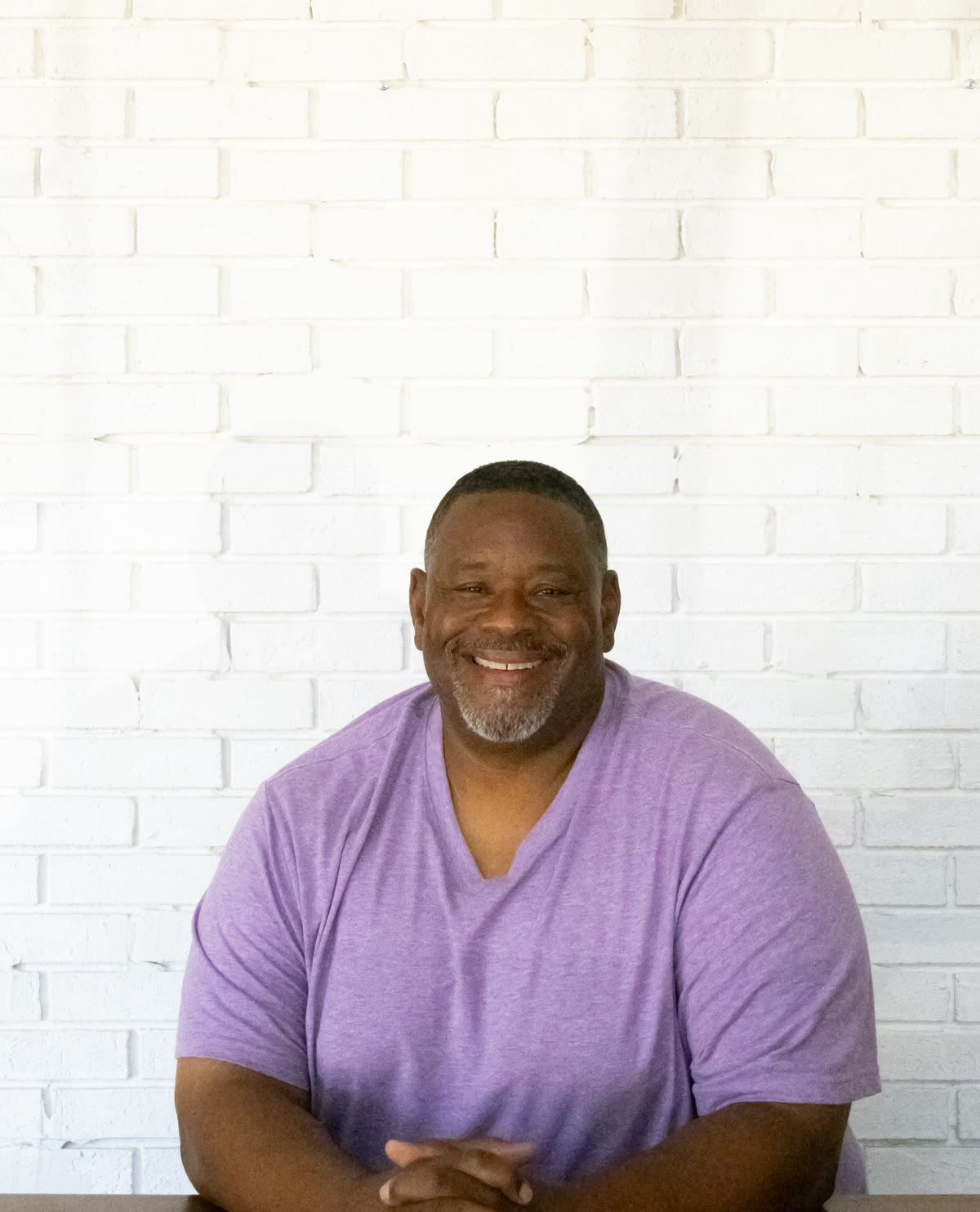Gino Mingo portrait against a white brick wall