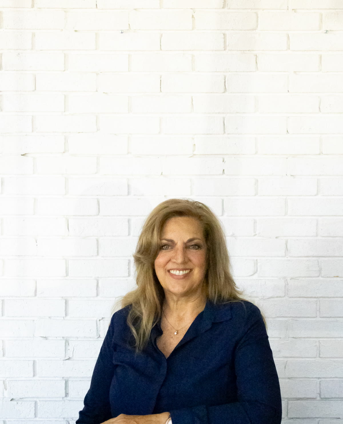 Michelle Mingo portrait against a white brick wall
