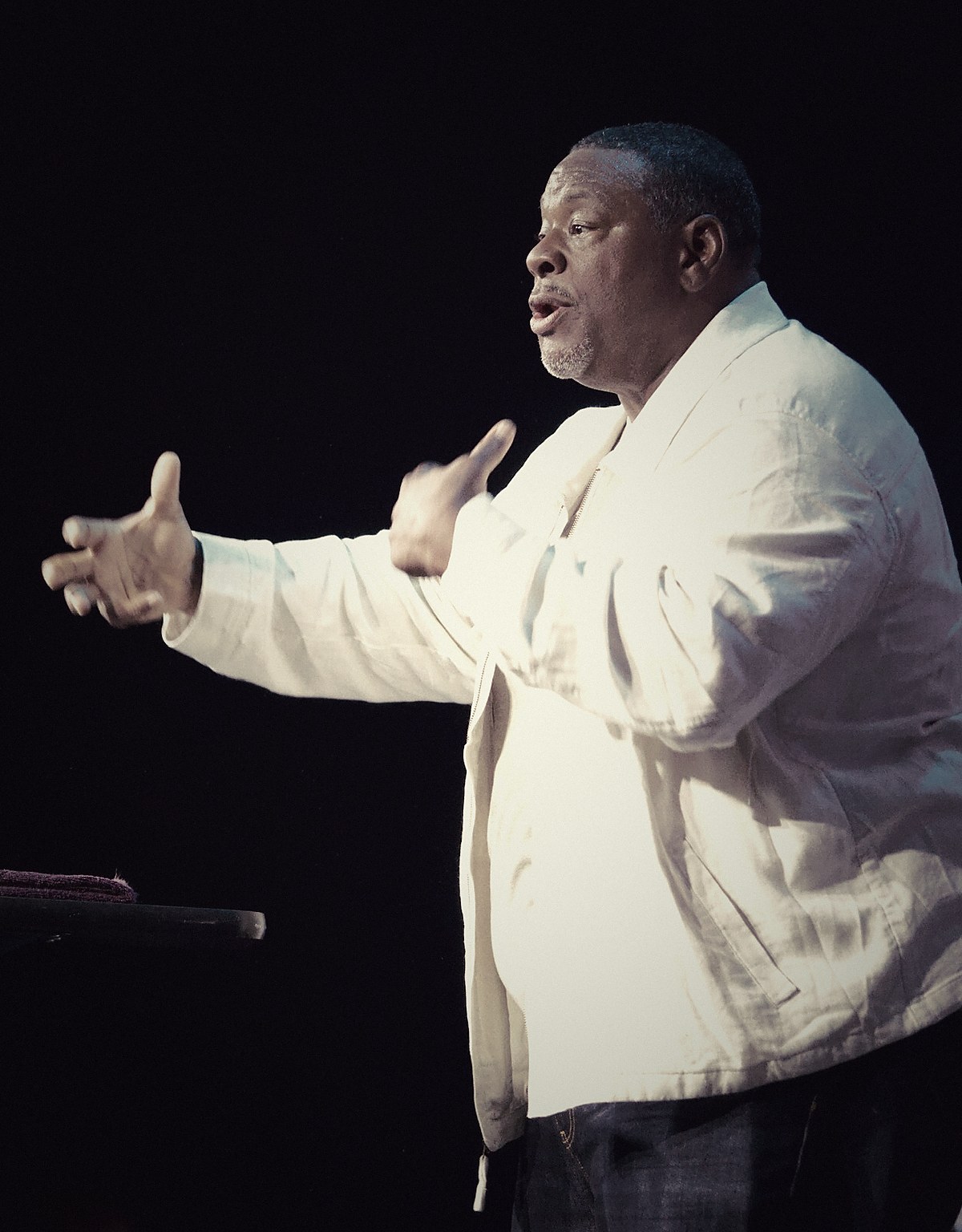 Gino Mingo speaking on stage during a ministry event